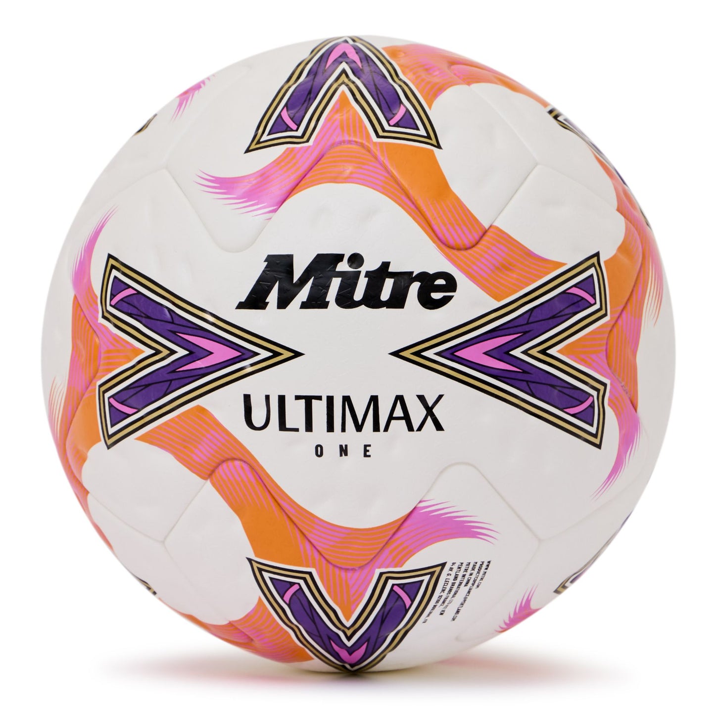 Mitre Ultimax One football resting on a grassy field, featuring classic black and white panel design for outdoor soccer matches.