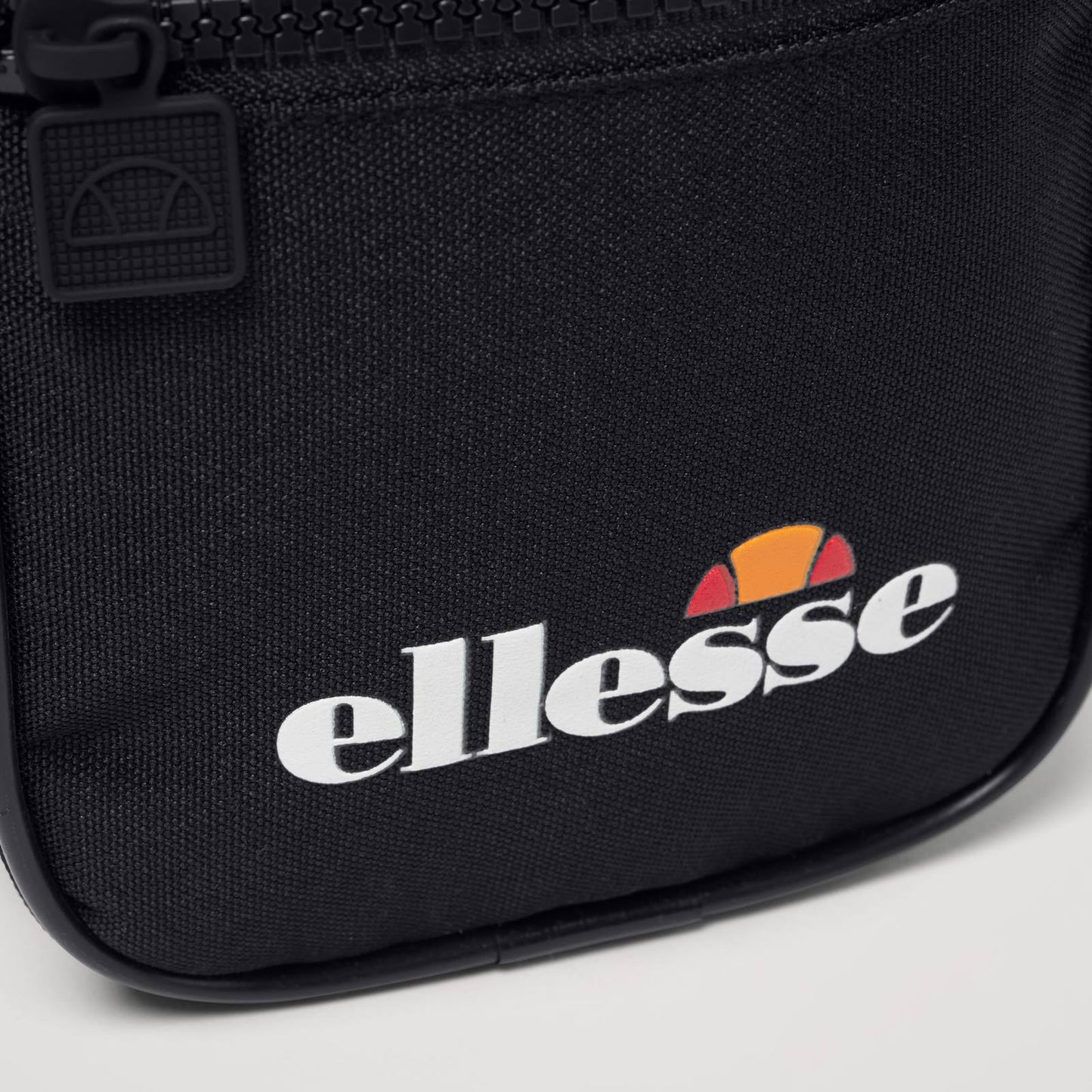 Ellesse Relo Small Item Bag in accessories, featuring compact design with adjustable strap and front zip pocket.