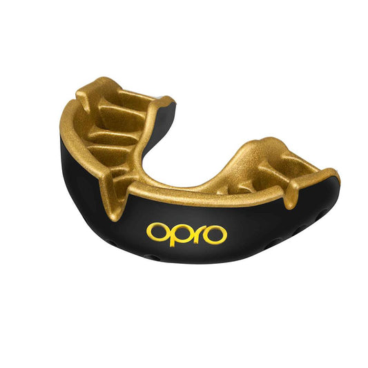 Opro Gold self-fit mouthguard in clear, flexible material, designed for sports protection, shown fitted in a mouthguard case.