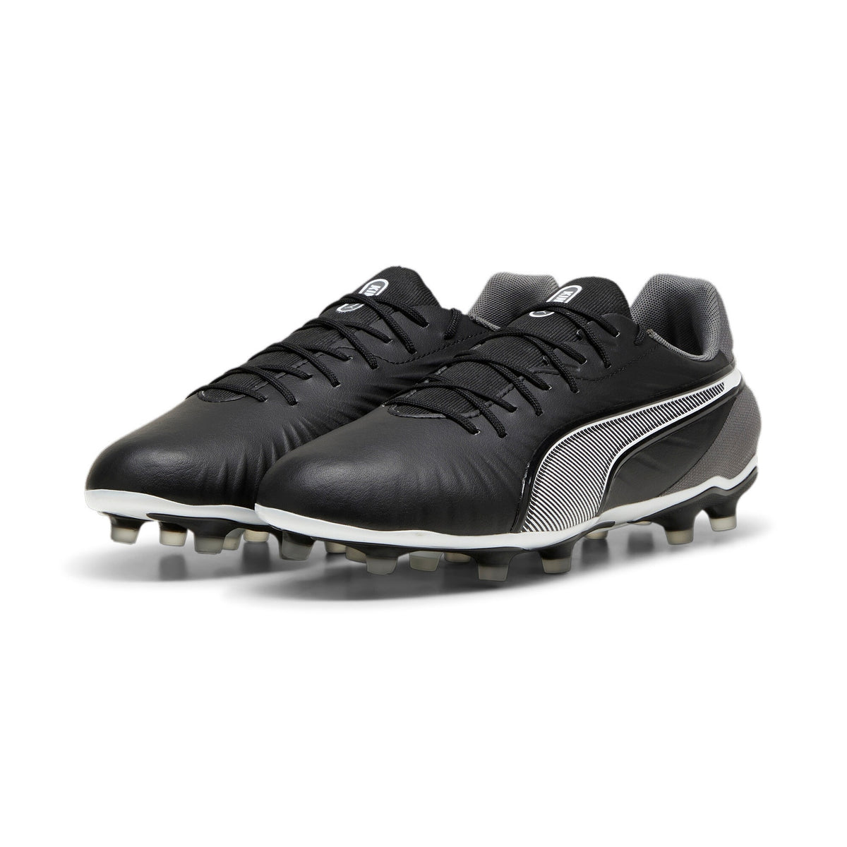 Puma King Match FG/AG football boots with black and white design, studded sole, and Puma logo on the side.