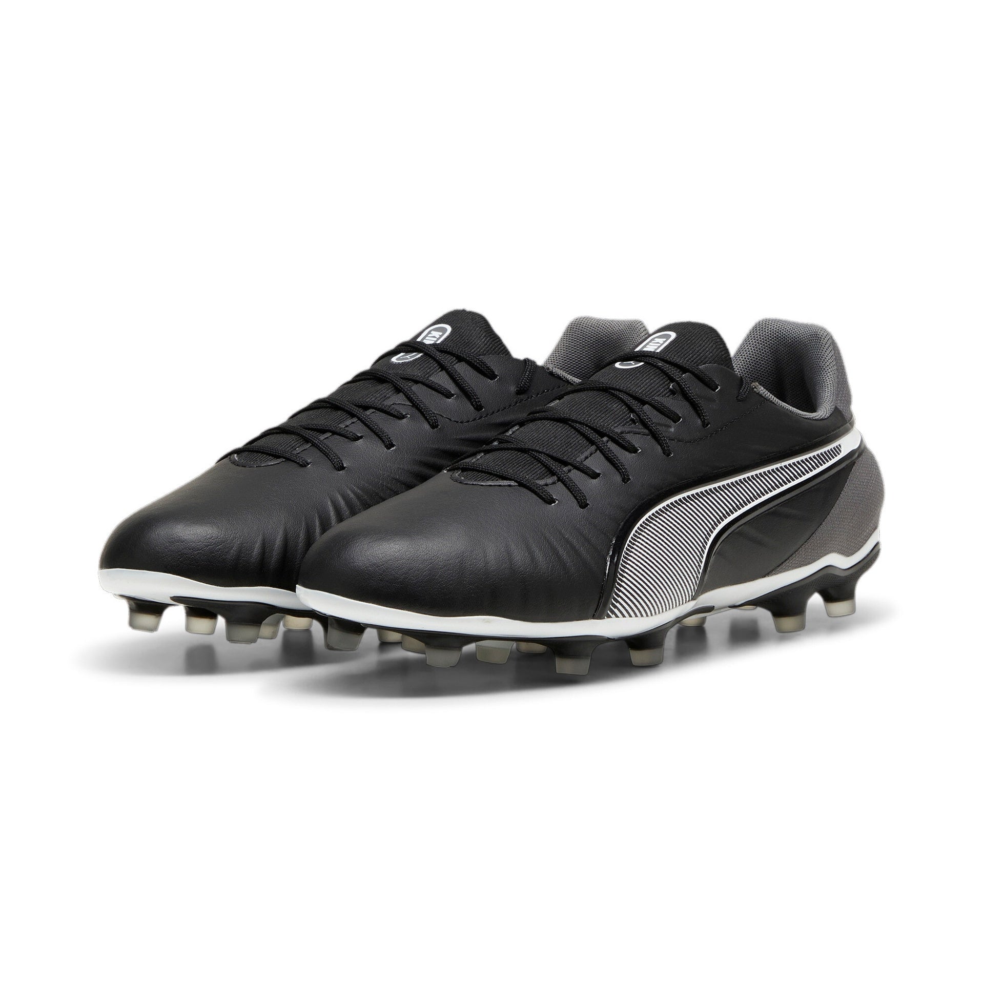 Puma King Match FG/AG football boots with black and white design, featuring studs for firm and artificial ground play.