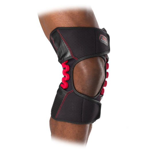 McDavid NRG Knee Over Wrap with Spring Hinge for sport support and stability, shown with adjustable straps and hinge mechanism.