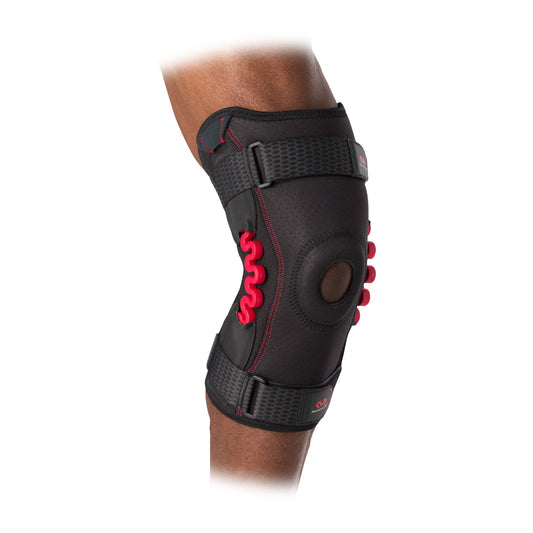 McDavid NRG Knee Brace with Spring Hinge showing adjustable straps and reinforced support for athletic knee stability and injury prevention.