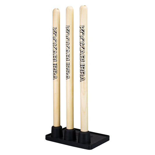 Kookaburra wooden practice stumps for cricket training, featuring three stumps and bails on a grassy field.