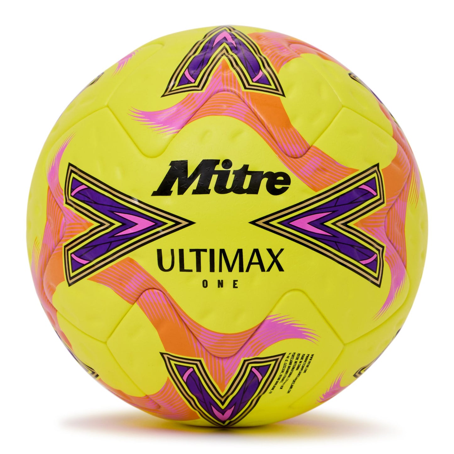 Mitre Ultimax One football resting on grass, showcasing its durable design and classic black and white panel pattern.