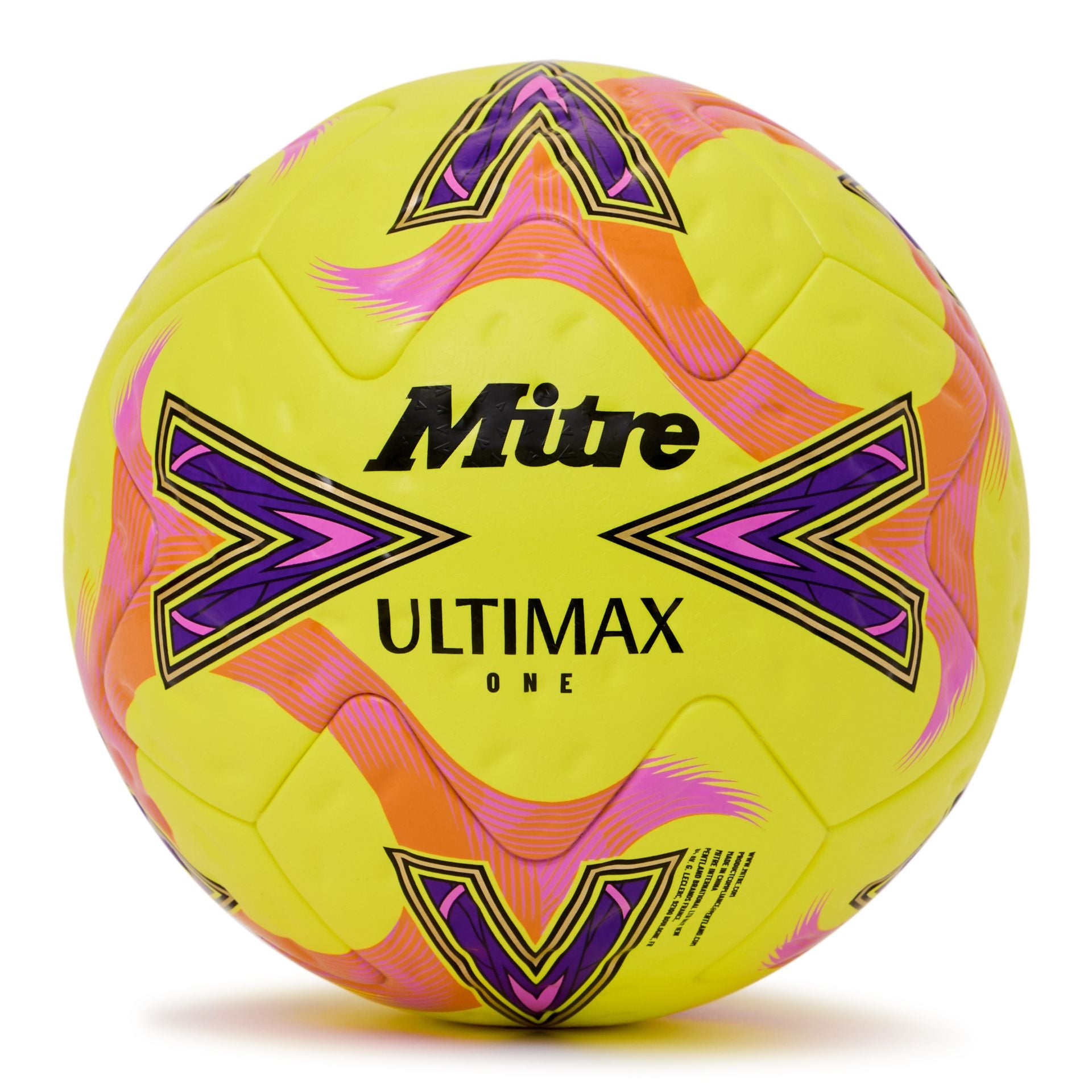 Mitre Ultimax One football resting on grass, showcasing its durable design and classic black and white panel pattern.