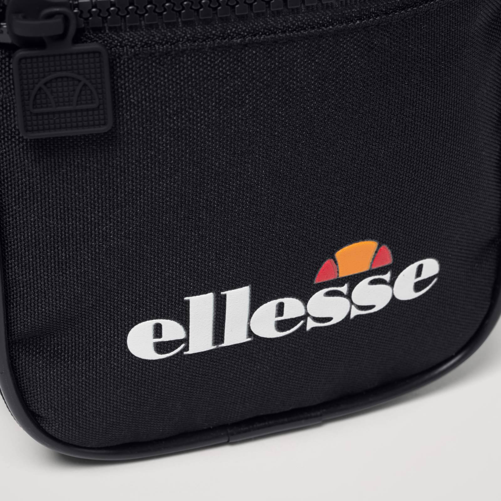 Ellesse Relo Small Item Bag in accessories, featuring compact design with adjustable strap and front zip pocket.