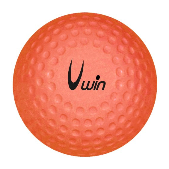 Uwin Dimple Hockey Ball resting on a wooden floor, showing the textured surface designed for improved grip and performance.