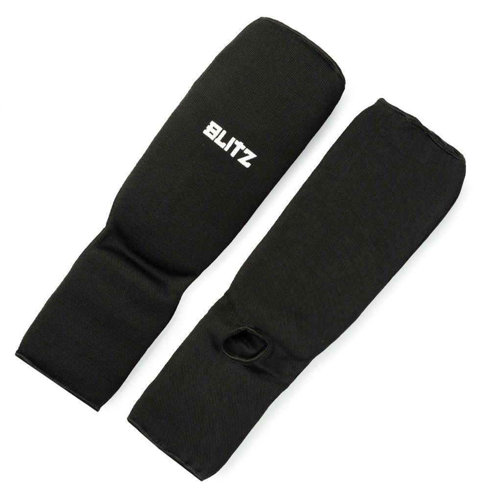 Black Blitz elastic shin and instep pads for martial arts protection, featuring adjustable straps and padded design.