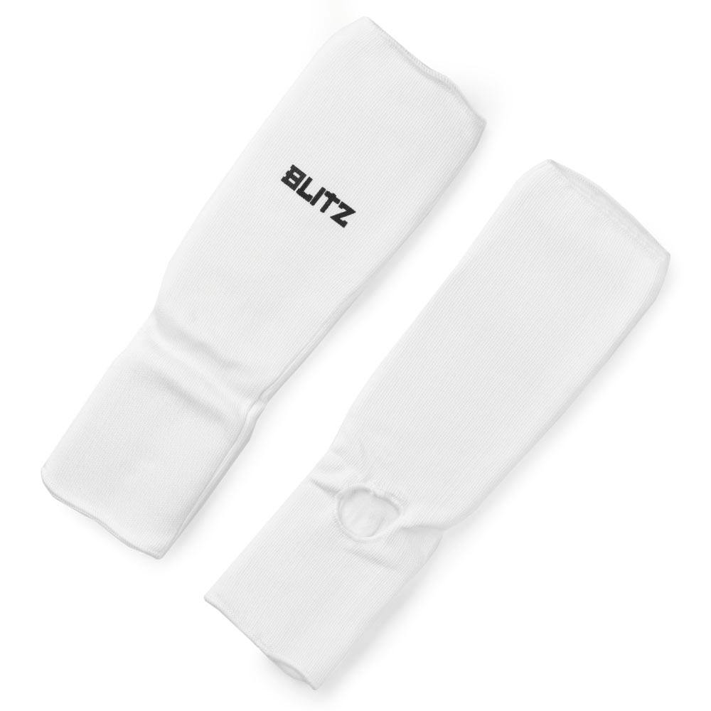 White Blitz elastic shin and instep pads for martial arts protection, showing flexible padding on shin guards.