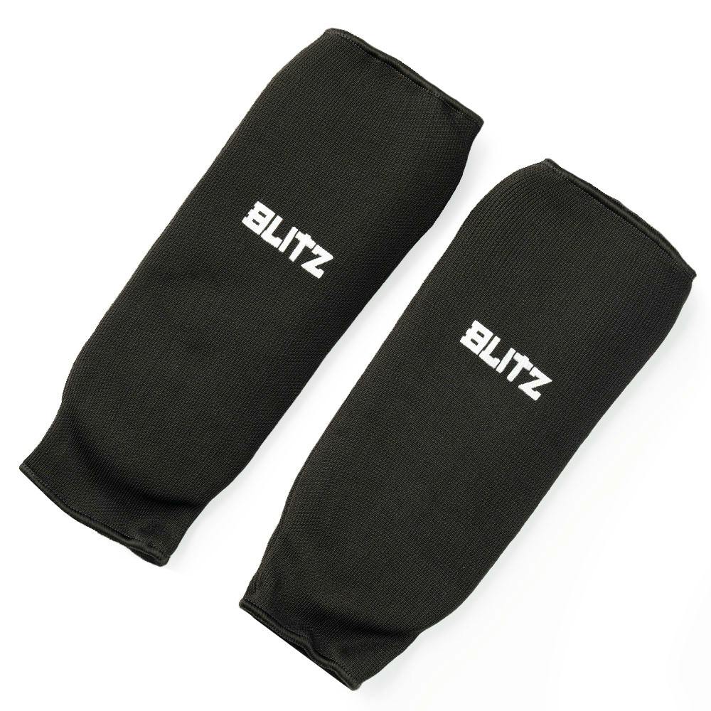 Black Blitz elastic shin pads for martial arts protection, featuring comfortable and flexible shin guard design.