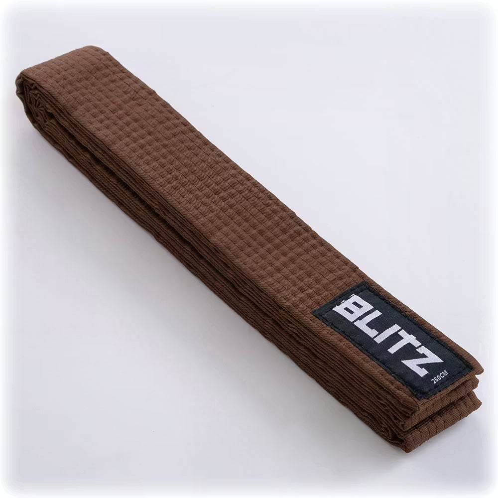 Brown Blitz plain martial arts belt lying flat, showing its simple design and smooth fabric for training and competition.