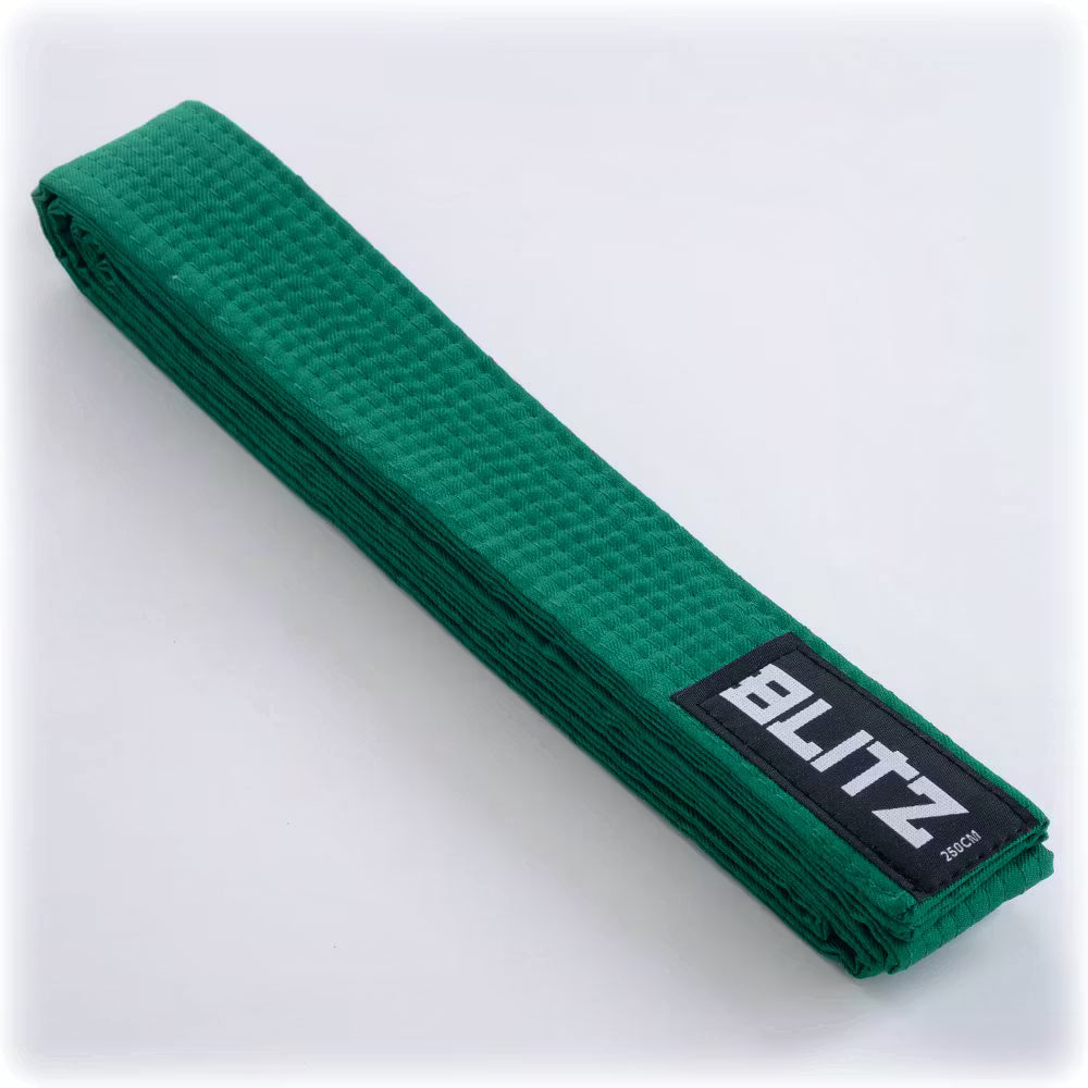 Green Blitz martial arts belt laid flat, showing its plain colored fabric and stitching details for training or competition use.