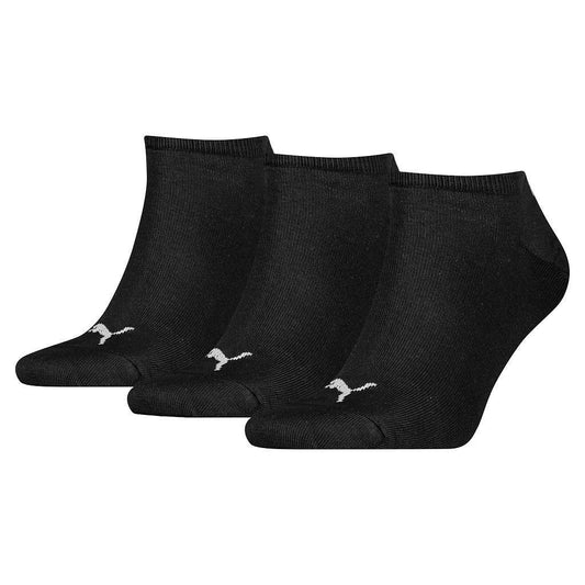 Puma invisible sock sneakers in black, shown with three pairs of low-cut athletic socks on a plain background.