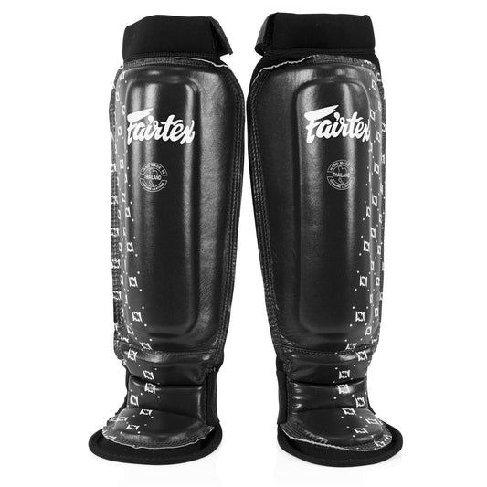Fairtex black neoprene MMA shin pads with padding and straps, designed for combat sports protection and training.